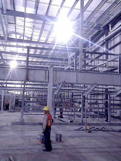Estructura metálica de Cinépolis Portal D10 en obra negra, con un trabajador al centro