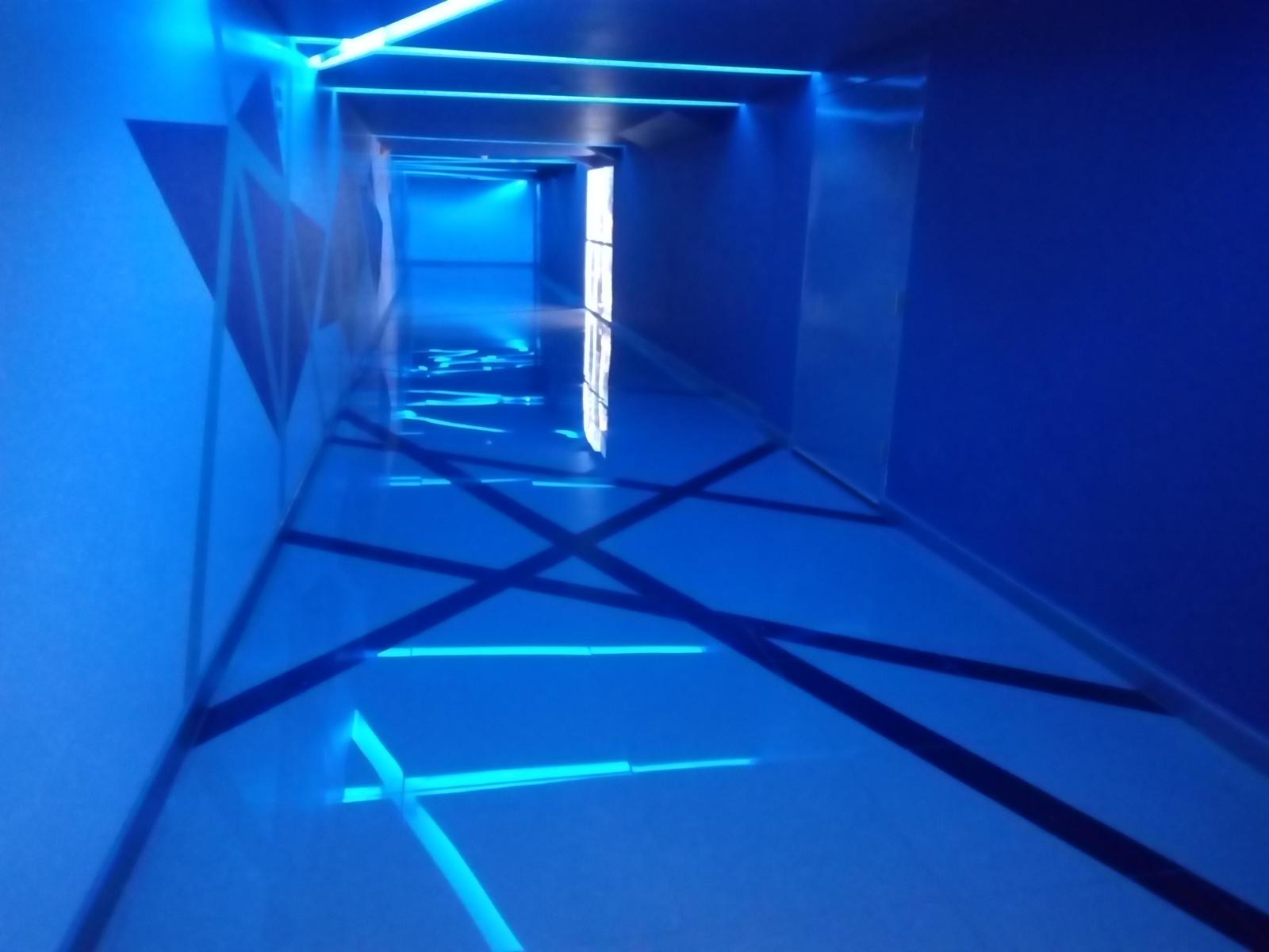 Pasillo de Cinépolis Portal D10 iluminado con líneas de luz azul