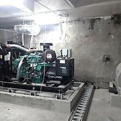Planta generadora de emergencia sobre su base, en un cuarto de máquinas
