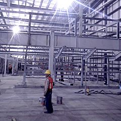 Estructura metálica en obra con un supervisor al centro